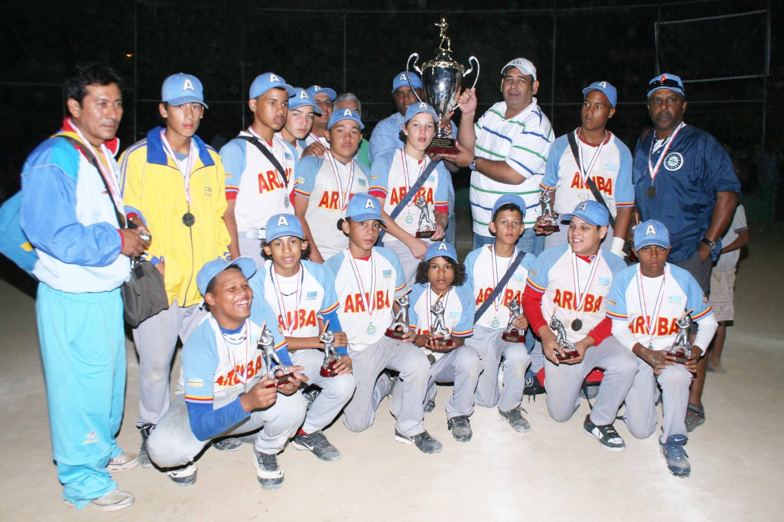 El Licenciado Ariel Vásquez entrega el trofeo de campeón a la delegación de Aruba los nuevos campeones del Mundialito de Moca